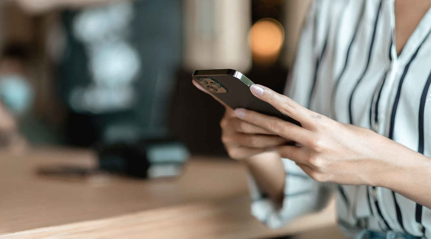 Photo de femme tenant son téléphone.